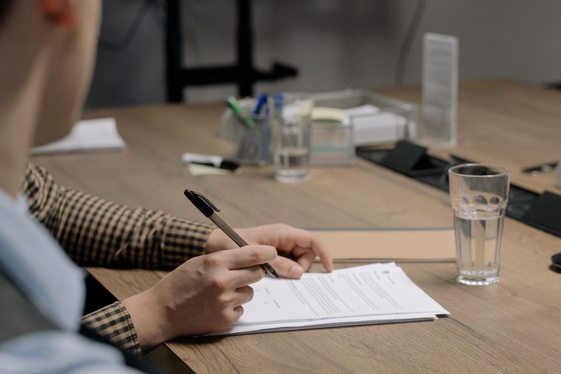 Persona firmando contrato profesional en reunión de negocios
